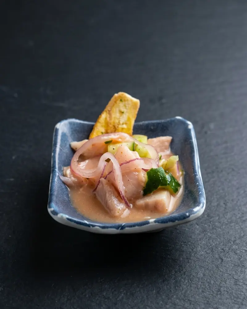 Cubos de peixe branco em molho cítrico, em tigela azul